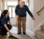 Caregiver and Elderly Man Discuss Rug Safety 90x80